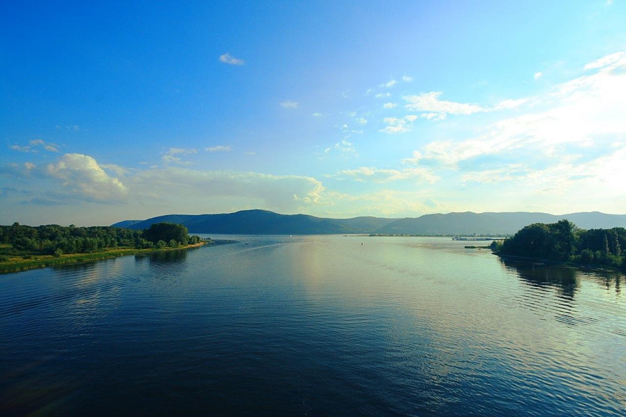 Панорама реки Волги с видом на широкое русло и зеленые берега